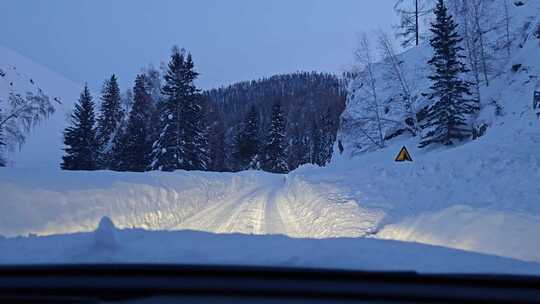 汽车行驶在大雪覆盖的新疆219国道上