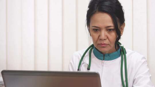 专注的亚洲女医生在临床环境中勤奋地在笔记