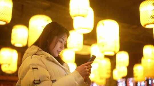 女性冬天穿羽绒服传统历史古镇景点使用手机
