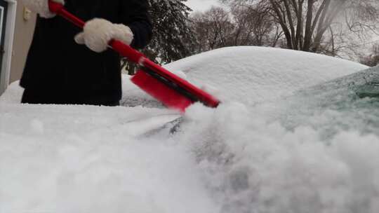 一个女人刷掉车里的雪