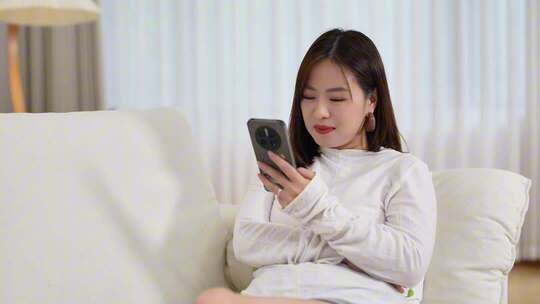女子沙发上专注看手机