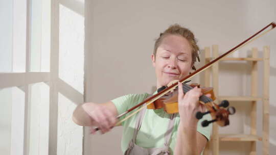 阳光明媚的日子里，快乐的女音乐家拉小提琴