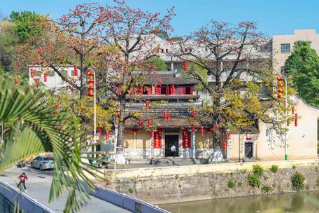 河边古建筑及盛开的红花树