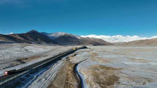 航拍冬季晴朗天气蓝天下雪峰公路视频