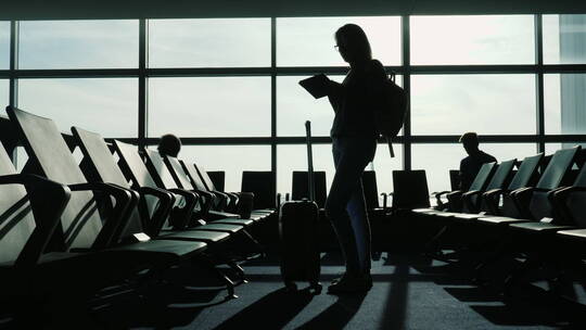 女人站在机场用平板电脑