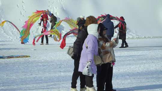 雪景公园中老年拍照舞龙绸红衣服东北