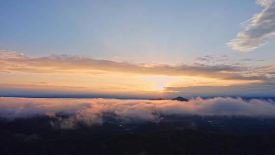 云雾之上，夕阳从云缝中露出来