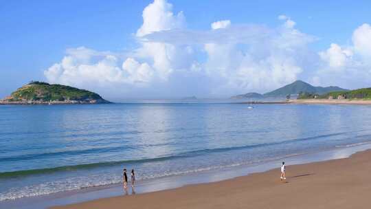 东山岛海边沙滩上有人在漫步的惬意场景