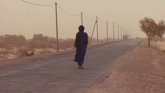 在沙漠路上行走的男人