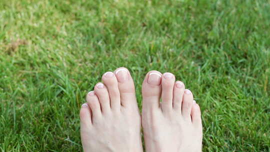 女人在草地上玩耍露出脚