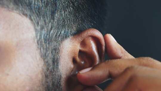 耳朵痛的年轻人触摸他疼痛的耳朵