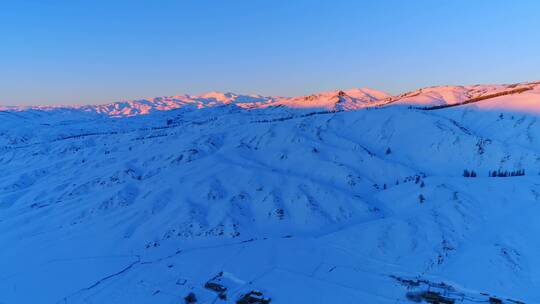 新疆阿勒泰雪山红色夕阳下的村落