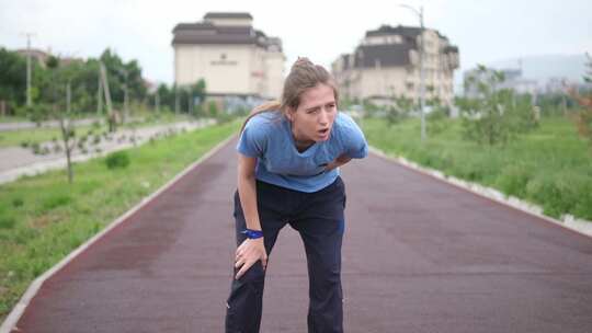 女子慢跑后呼吸沉重城市公园年轻女孩跑步运