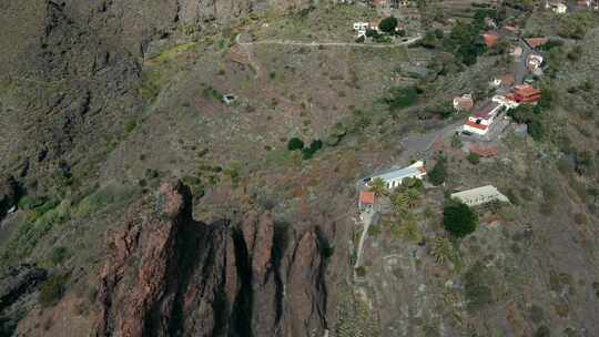 空中倾斜向下揭示山边村庄的尖岩形成，白天