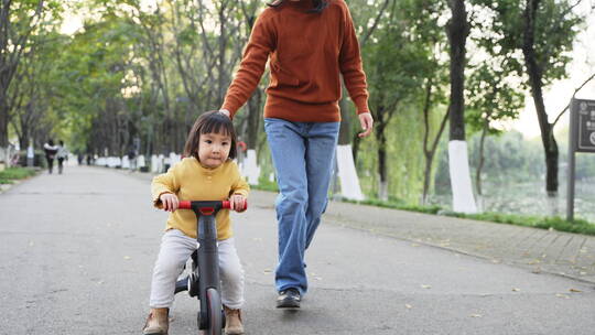 妈妈陪小宝宝在公园里骑车