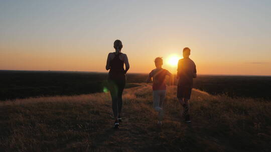 日落时分一家人在草地上跑步