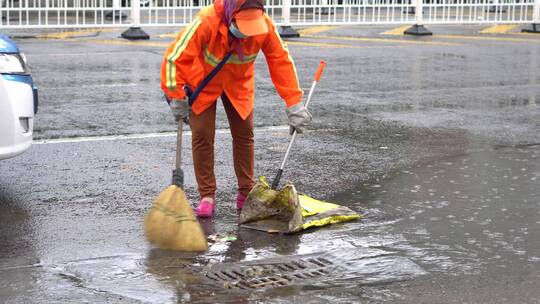 下雨天环卫清洁工人打扫街道