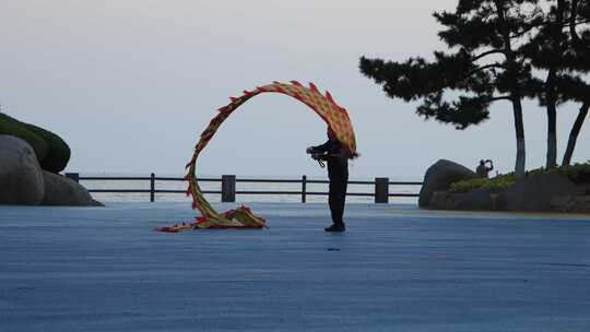 山东威海经区悦海公园灯塔广场清晨舞龙老人