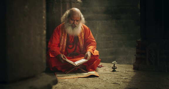 印度老和尚在古庙看书的慢动作肖像。