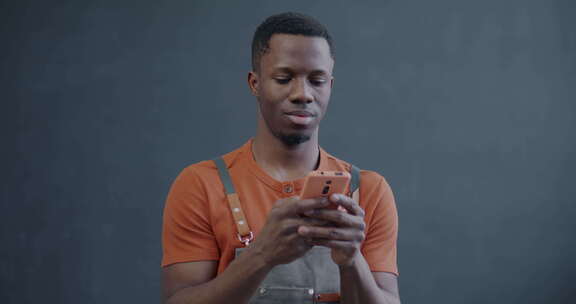 围裙上的非裔美国人使用智能手机发短信，使