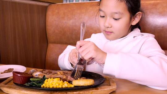 4K升格实拍堂食在西餐厅切牛排的亚洲女孩视频素材模板下载