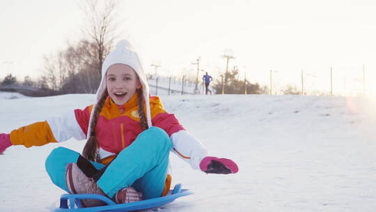 女孩在雪山上骑雪橇