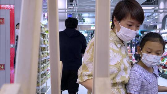 疫情期间戴口罩在商场超市采购商品的母女