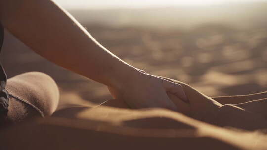 女人的手倾泻沙漠沙子