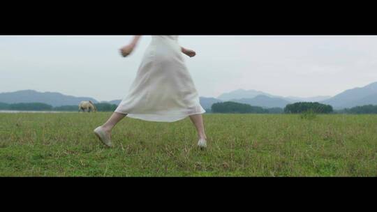 白色连衣裙女子在草原上旋转跳舞舞步特写