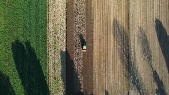 农用拖拉机带苗床耕作机在农田耕地上的鸟瞰