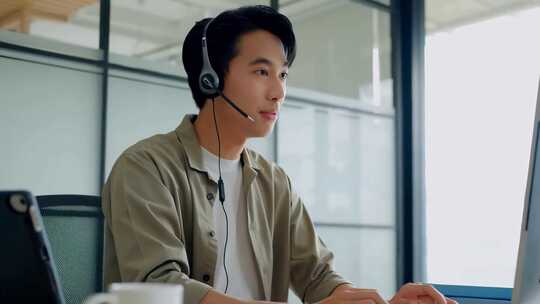 戴耳机男士办公室使用电脑