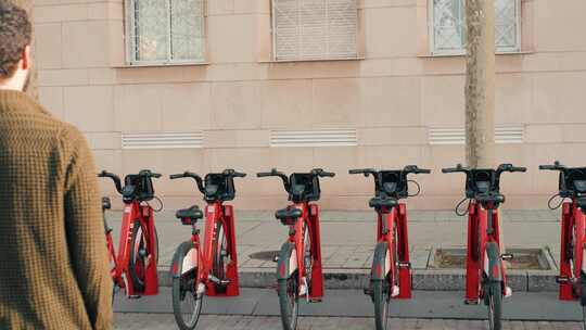 游客在共享停车场乘坐电动脚踏车或自行车旅