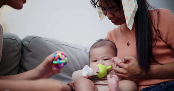 两个女人在家里客厅的沙发上开心地和一个小