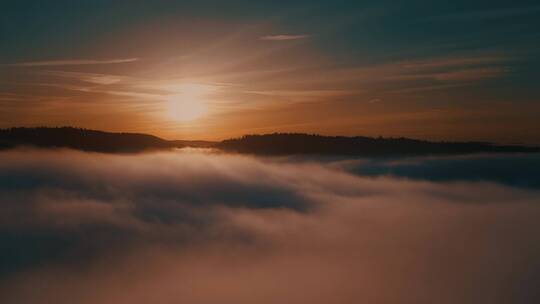 日出时分云雾缭绕的山林天际线景观