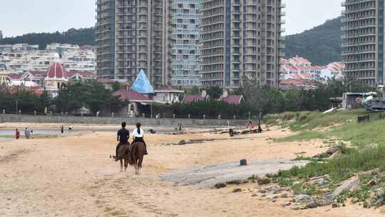 航拍威海市环翠区金海路沙滩上的骑马人