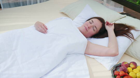 清晨女人躺在床上伸懒腰视频素材模板下载