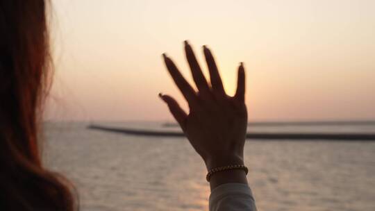 年轻女性挥手向夕阳告别