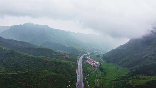 山间云雾中蜿蜒的公路和村庄