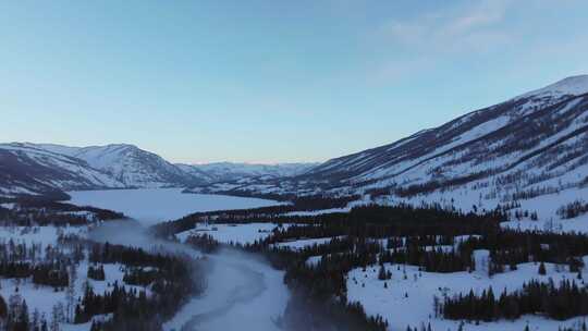 航拍新疆冬季喀纳斯河流晨雾雪山森林雪景