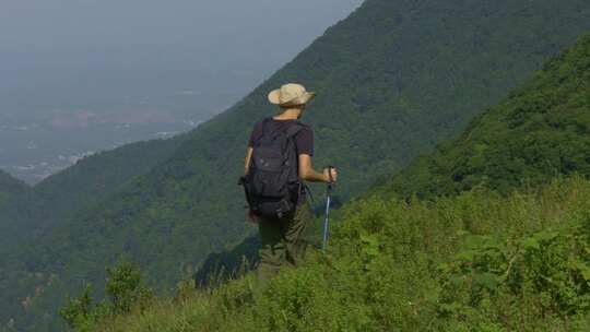 背包者山间持杖徒步远望