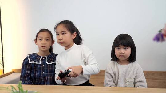 坐在客厅沙发上玩电子游戏的三个女孩