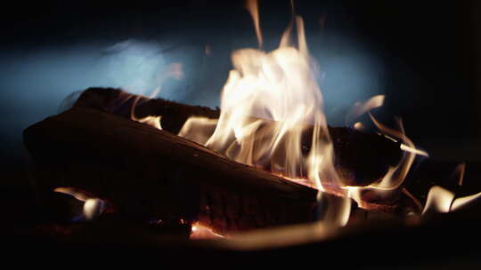 篝火上燃烧木头的特写镜头，背景是抽象的汽