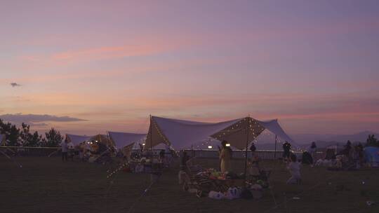黄昏时刻一群人在露营野餐