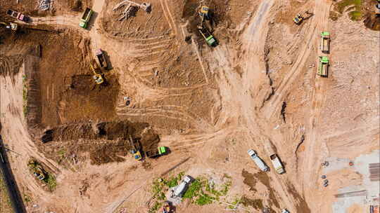 航拍建筑工地挖掘机与渣土车施工现场