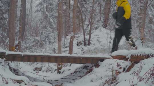 男人在冬天冰雪的森林步行奔跑