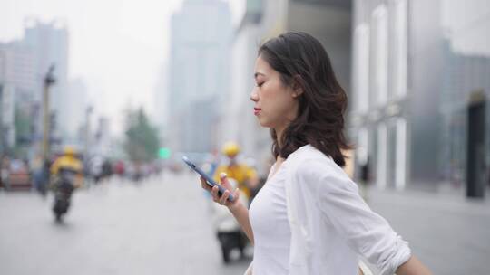 美女成都街头漫步看手机的都市白领