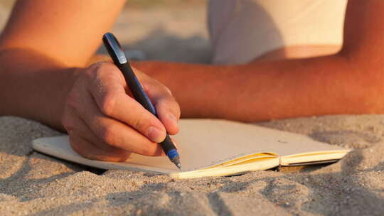 在沙滩上拿笔写字