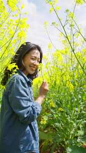 油菜花海里赏花的美女特写春天阳光温暖