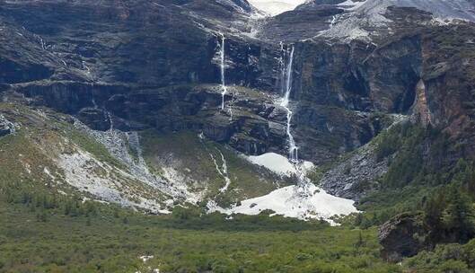 川西稻城雪山间流水瀑布绿地蓝天