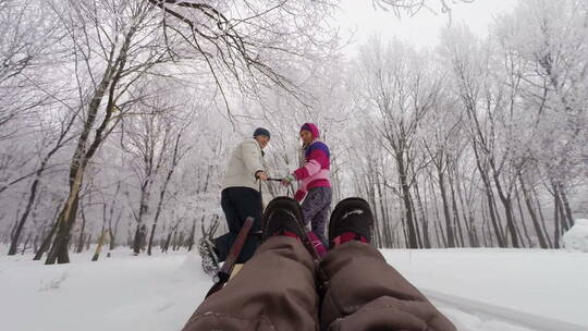 父母拉着坐在雪橇上的女儿